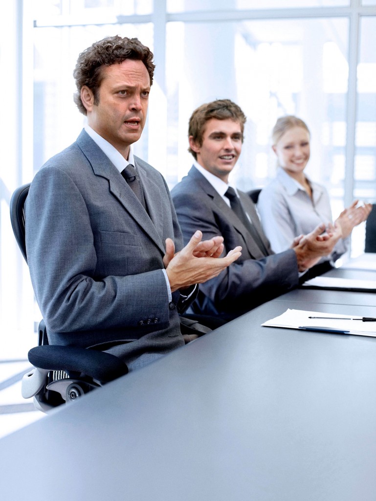 Successful applauding executives sitting at the table